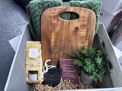 Personalized realtor closing gift basket with walnut board, blanket, diffuser, faux plant, notebook, and house coasters