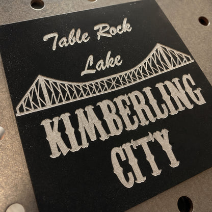 Close-up of engraved Kimberling City bridge on black acrylic magnet